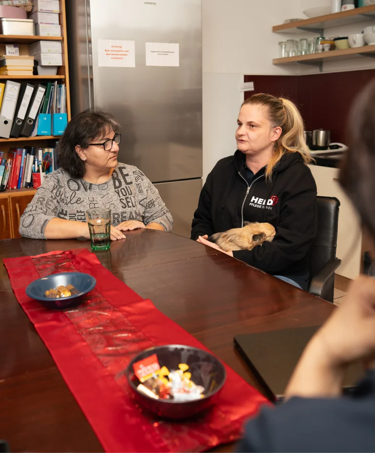 Pflegekolleginnen von Held Pflege Bonn im fachlichen Austausch am Besprechungstisch.