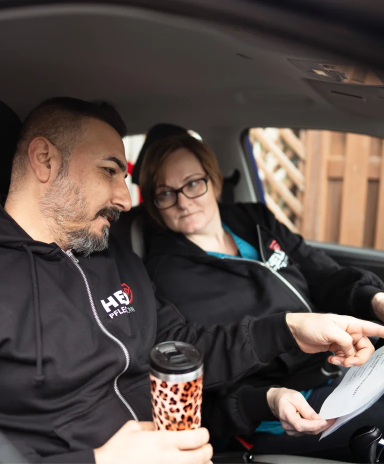 Pflegekräfte von Held Pflege Bonn besprechen Einsatzdetails gemeinsam im Auto.