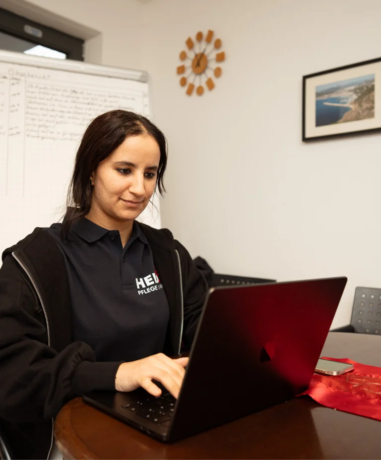 Mitarbeiterin von Held Pflege Bonn arbeitet konzentriert an der Pflegedokumentation am Laptop.