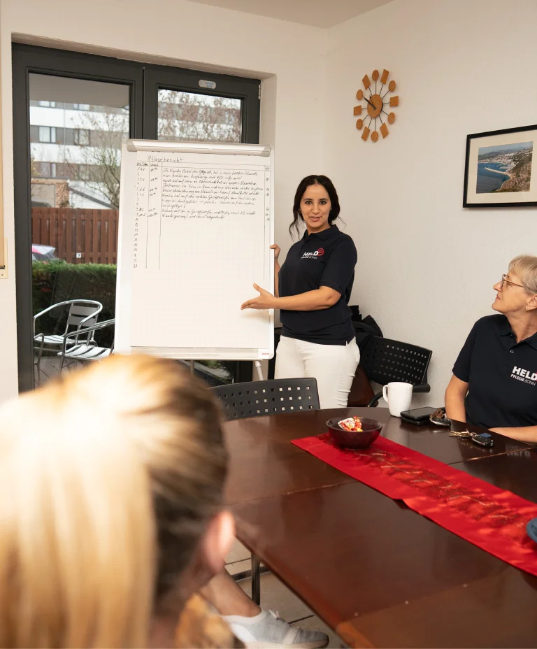 Pflegemitarbeiterin von Held Pflege Bonn präsentiert Informationen bei einer internen Besprechung