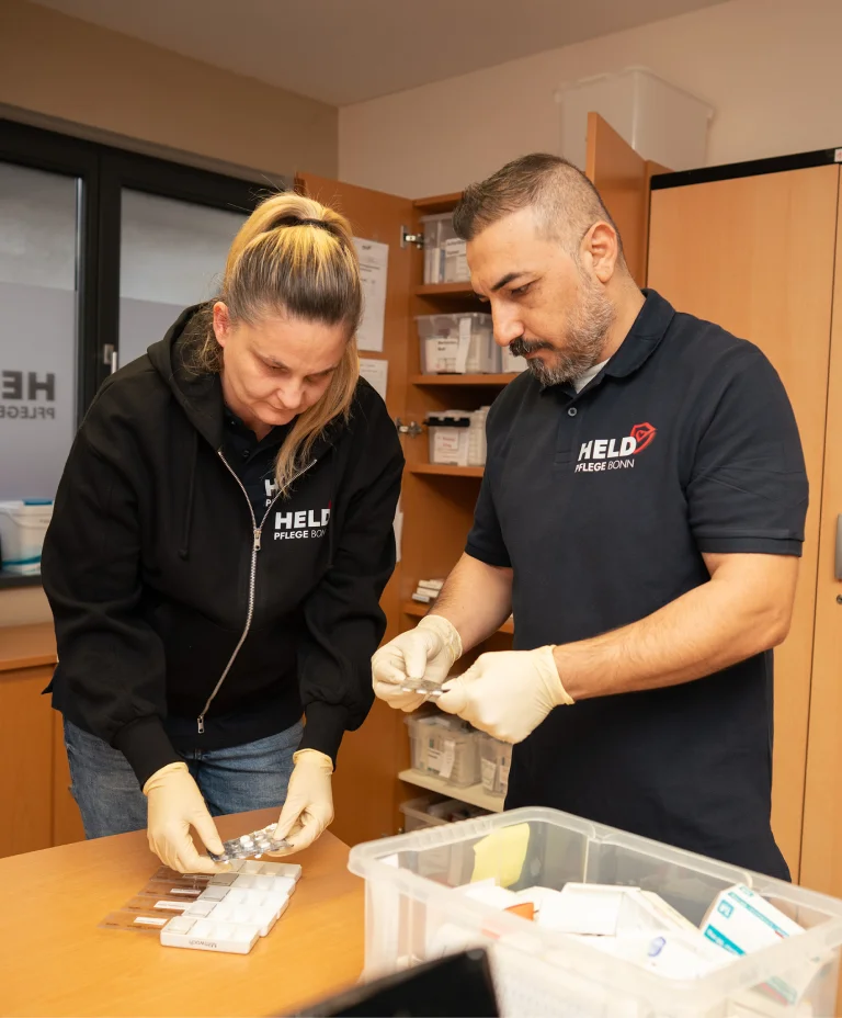 Pflegekräfte von Held Pflege Bonn bereiten gemeinsam pflegerische Materialien vor.