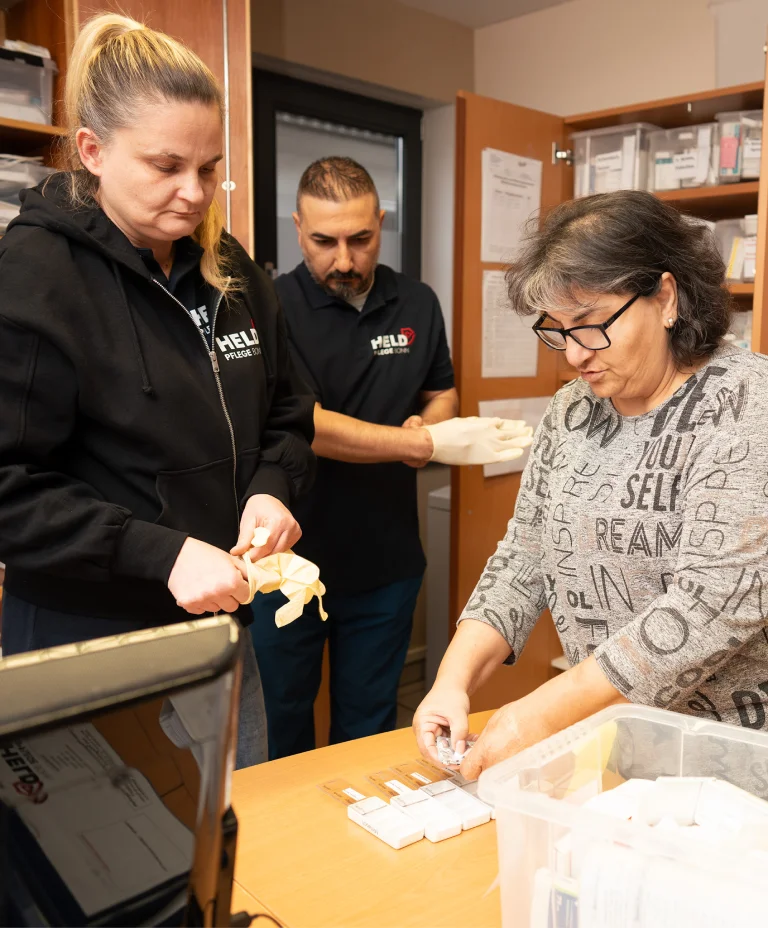 Pflegekräfte von Held Pflege Bonn helfen einer Patientin bei der Essensvorbereitung.